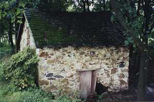 An old stone spring house with some stone missing