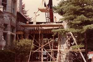 Workers transporting materials to repair a stone archway