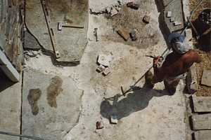 Stone patio being carefully disassembled for restoration