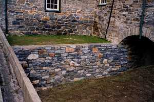 a brand new stone retaining wall under a bridge and leading to a tunnel - after 