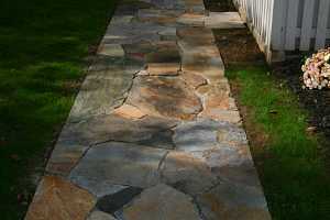 a newly installed stone sidewalk leading up to a porch