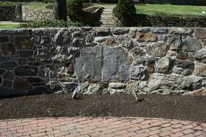 a stone wall that contains to larger stones in the middle with an engraved message