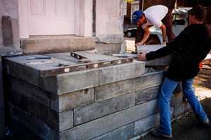 two men installing large stone blocks for steps