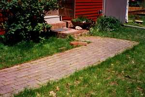 a brick walkway leading to brick steps and a front door - before