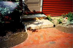 a brick walkway leading to new stone steps and a front door - after