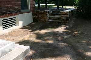 stepping stones leading from concrete stairs to natural stone steps and wall