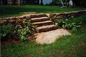 natural stone steps in between a natural stone retaining wall