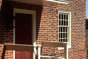 a new stone step and porch railing leading to the front door of a brick home