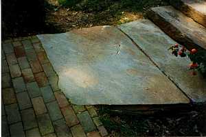 a closeup of the stone landing that connects to a brick walkway