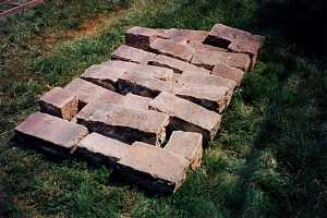 stones laid out in a wall shape on the grass