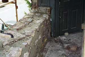 a new stone wall partially built on the 2nd story of a building