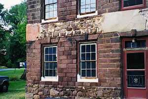 a repaired stone wall section on a stone home