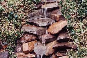 a new stone waterfall installation on a hill - after