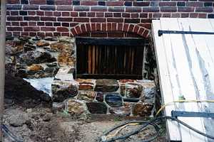 a stone window well next to a cellar door