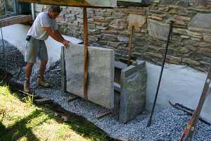 a man placing the stone frame for a window well