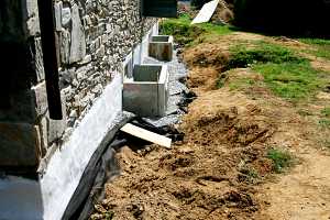 two new stone window well frames sitting on a road stone base